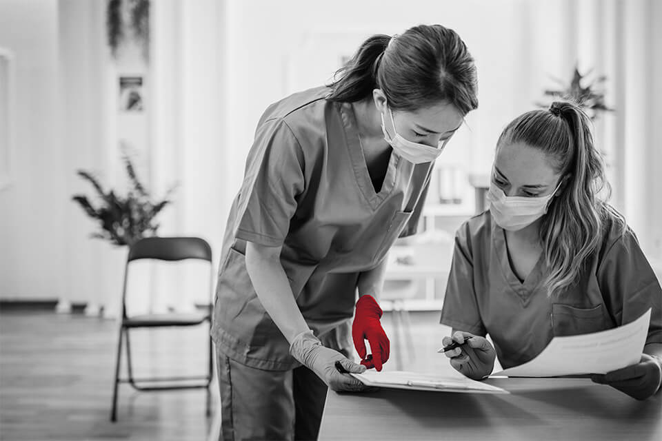 two healthcare nurses looking at medical documents