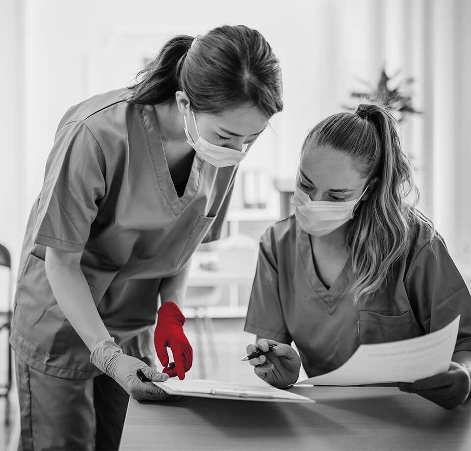 two healthcare nurses looking at medical documents